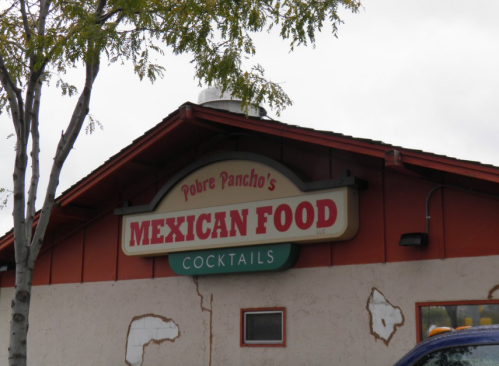Sign for Pobre Pancho's Mexican Food, featuring the words "Mexican Food" and "Cocktails" on a red and white building.