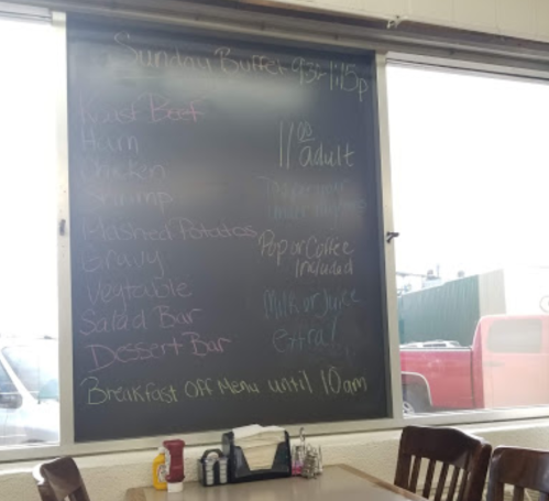 Chalkboard menu listing Sunday buffet items and prices, with a note about breakfast hours and drink options.