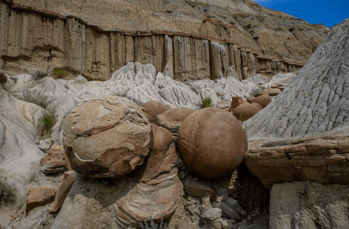 Rock formations with large, round boulders in a rugged landscape under a clear blue sky.