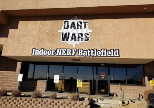 Sign for "DART WARS Indoor NERF Battlefield" on a building entrance, with a clear view of the exterior.