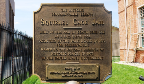 Plaque detailing the history of the Squirrel Cage Jail, built in 1868 and preserved as a historic site.