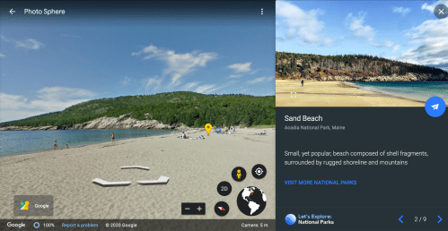 A sandy beach at Acadia National Park, Maine, surrounded by mountains and rugged shoreline under a clear blue sky.