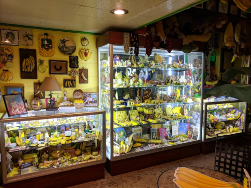 A colorful display of banana-themed collectibles in glass cases, surrounded by banana decorations on the walls.