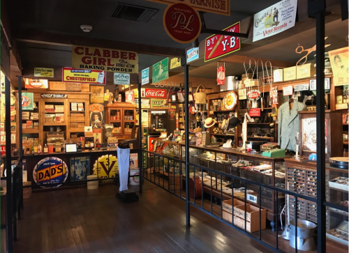 A vintage store interior filled with old signs, products, and memorabilia, showcasing a nostalgic atmosphere.