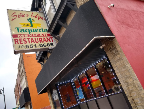 Sign for Señor López Taqueria, a Mexican restaurant, with a colorful exterior and illuminated windows.
