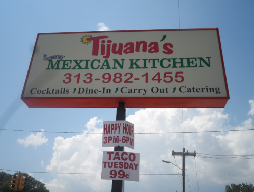 Sign for Tijuana's Mexican Kitchen featuring contact info, happy hour details, and Taco Tuesday promotion.
