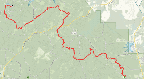 Map showing a winding red trail through a green landscape, with notable locations marked along the route.