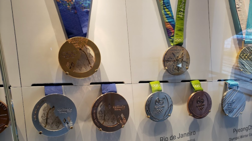 Display of Olympic medals from various games, featuring colorful ribbons and intricate designs.