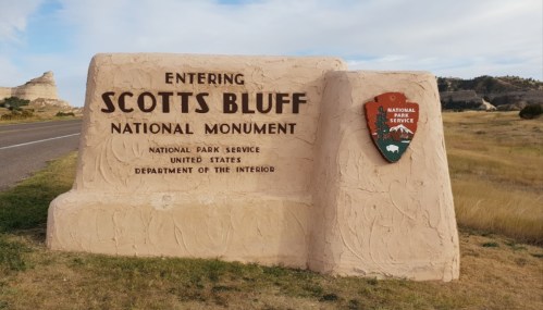 Sign marking the entrance to Scotts Bluff National Monument, featuring the National Park Service emblem.