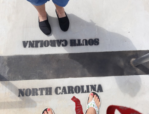 Feet standing on a surface marked with "NORTH CAROLINA" and "SOUTH CAROLINA" in bold letters.