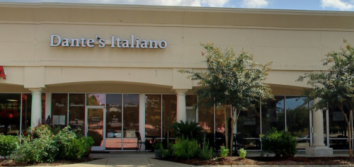 Exterior view of Dante's Italiano restaurant, featuring large windows and greenery in front.