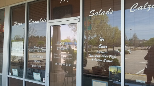 Front entrance of Dante's Italiano restaurant, featuring menu items like pizza, stromboli, and salads. Hours displayed.