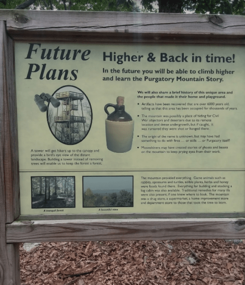 Sign detailing future plans for climbing and learning about Purgatory Mountain, featuring a tower and historical artifacts.