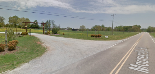 A gravel driveway leads to a fenced property with trees and a barn, alongside a paved road labeled Mooresville Road.