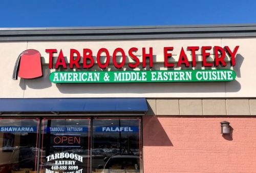 Sign for Tarboosh Eatery, featuring "American & Middle Eastern Cuisine," with menu items like shawarma and falafel.