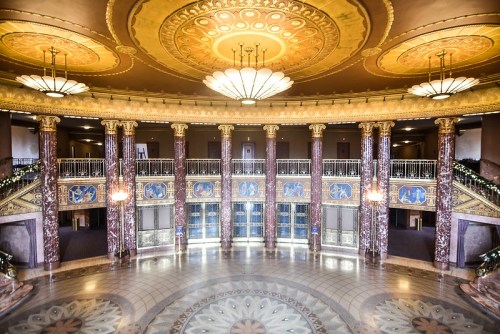 Elegant interior of a grand hall featuring ornate ceilings, decorative columns, and intricate floor patterns.