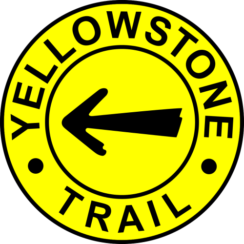 Yellow circular sign with black text "YELLOWSTONE" at the top, "TRAIL" at the bottom, and a left-pointing arrow in the center.