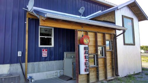 A rustic building with a blue exterior, wooden accents, and a sign reading "OPEN" near the entrance.