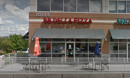 Exterior of BB Deli & Pizza with outdoor seating and umbrellas, located at 10155, under a partly cloudy sky.
