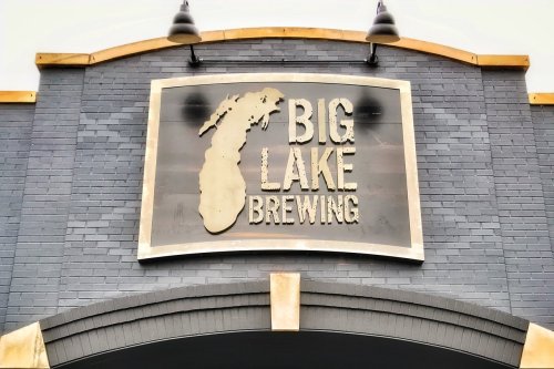 Sign for Big Lake Brewing featuring the outline of Michigan and bold lettering on a gray brick background.
