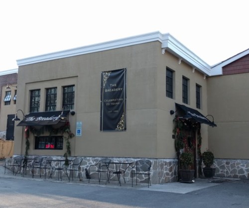 Exterior of The Breadery, featuring a banner for its 20th anniversary and outdoor seating.