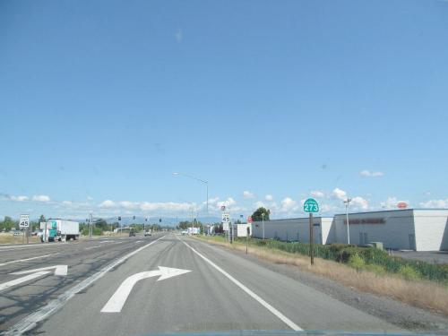 A highway scene with a clear blue sky, road signs, and a left turn lane, indicating Route 273.