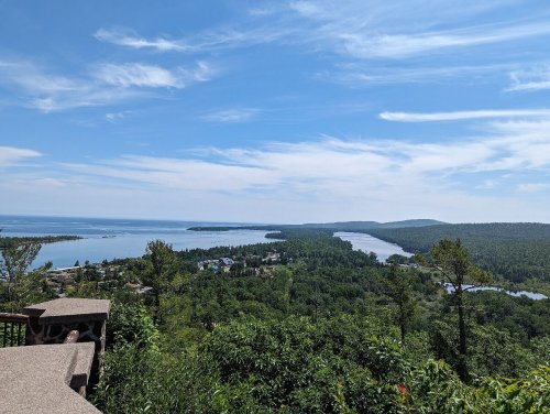 A scenic view of a lush green landscape with rivers and lakes under a clear blue sky.