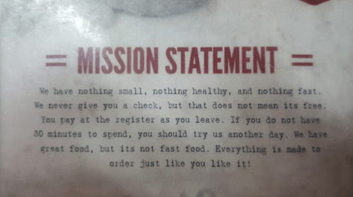 Text on a menu stating the mission statement about food quality and service expectations.