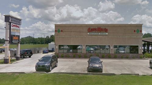 Exterior view of Casa Maria Mexican Grill with parked cars and a sign for Gonzales Plaza in the foreground.