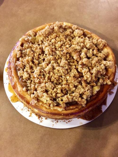 A delicious cheesecake topped with a generous layer of crumbly streusel and caramel drizzle.