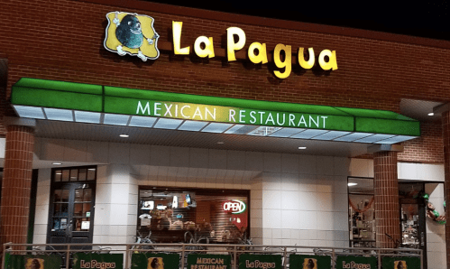 Exterior of La Pagua Mexican Restaurant, featuring a bright green sign and an "Open" neon light.