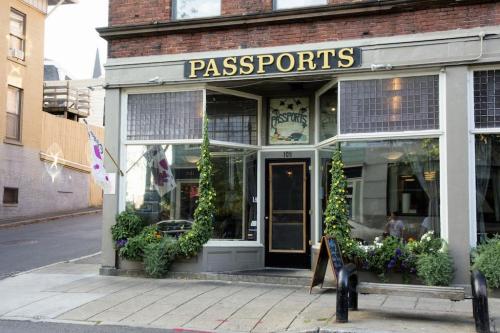 Exterior of a restaurant named "Passports," featuring large windows and greenery around the entrance.