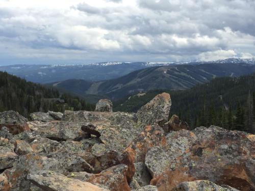 A rocky landscape with distant mountains and a cloudy sky, showcasing a scenic view of nature.