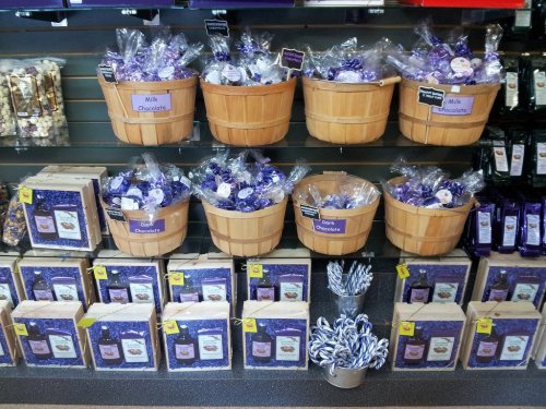 Baskets of milk chocolate and assorted candies displayed on a store shelf, with purple-themed packaging.