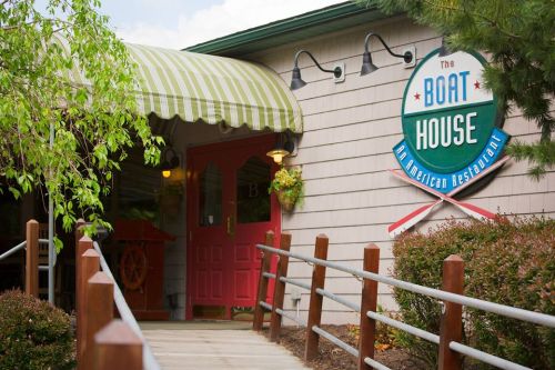 Entrance of The Boat House restaurant, featuring a green striped awning and a colorful sign.