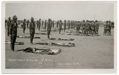 Soldiers in uniform inspect a battalion in Columbus, New Mexico, with tents and equipment laid out on the ground.