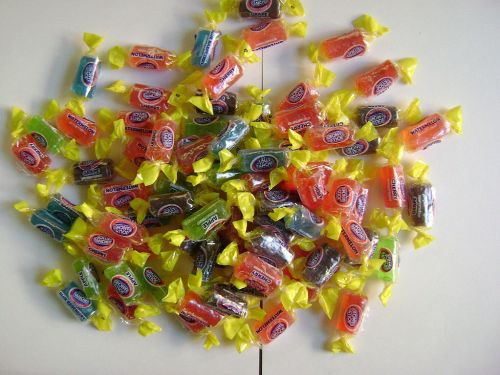 A colorful assortment of wrapped candies scattered on a white surface.