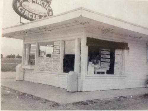 A vintage ice cream shop with a sign reading "Arctic Circle," featuring a menu of treats displayed in the window.