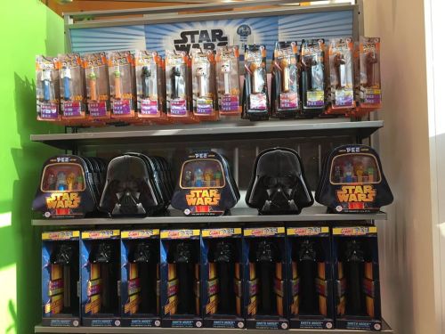 A display of Star Wars merchandise featuring action figures, Darth Vader backpacks, and lightsaber toys.