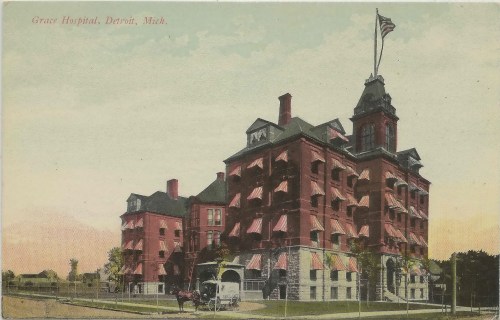 Historic postcard of Grace Hospital in Detroit, featuring a red brick building with a flag and horse-drawn carriage.