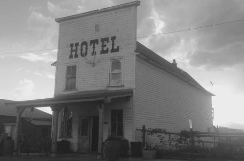 A vintage hotel building with a wooden facade, featuring the word "HOTEL" prominently displayed.