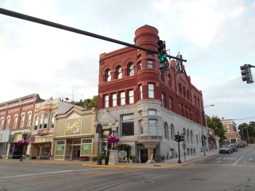 Historic brick buildings at a street intersection, featuring ornate architecture and traffic lights.
