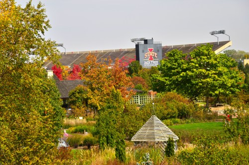 View of Jack Trice Stadium surrounded by colorful trees and greenery on a clear day.