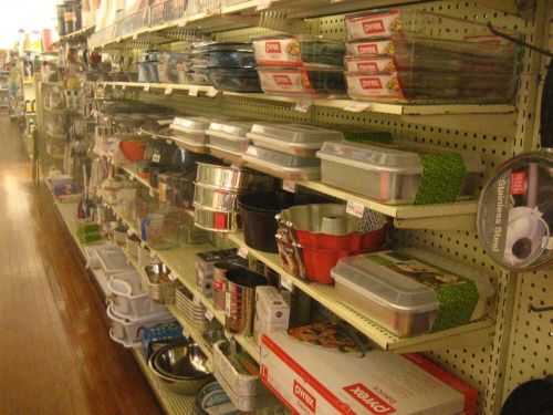 A store aisle filled with various kitchenware, including containers, bowls, and utensils on shelves.