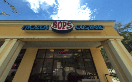 Sign for Bop's Frozen Custard with "OPEN" neon light, bright blue sky in the background.