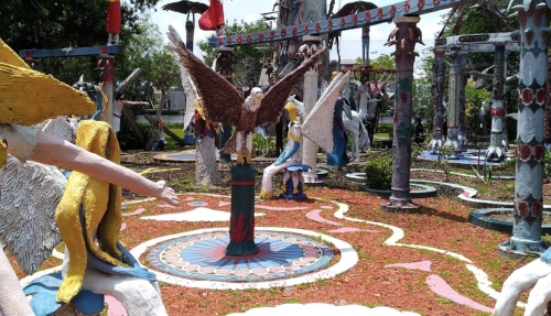 Colorful sculptures of angels and mythical creatures in a vibrant outdoor garden setting.