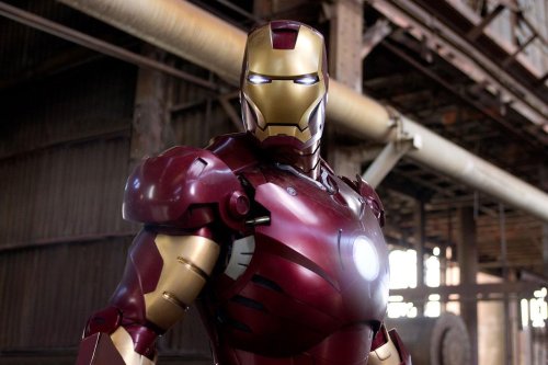 A close-up of Iron Man in his iconic red and gold armor, standing in an industrial setting.