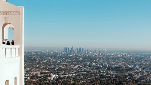 View of downtown Los Angeles from the Griffith Observatory, with clear skies and cityscape in the background.