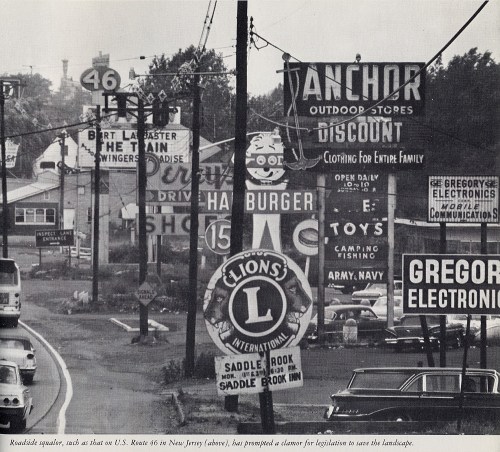 Black and white photo of roadside signs along U.S. Route 46 in New Jersey, showcasing various businesses and advertisements.