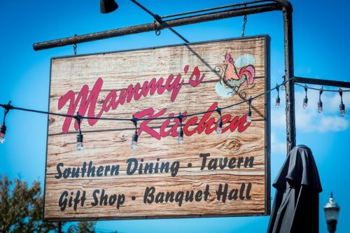 Sign for "Mammy's Kitchen" featuring Southern dining, a tavern, gift shop, and banquet hall, with decorative lights.